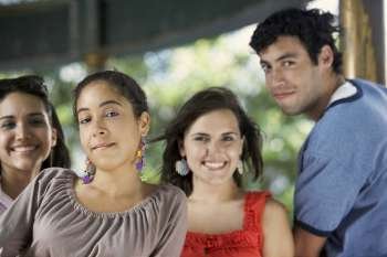 Portrait of a young man with three young women posing and smiling