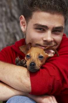 Portrait of a young man hugging his pet