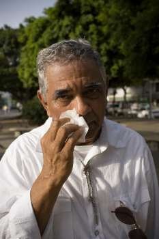 Senior man with allergy symptoms, outdoors