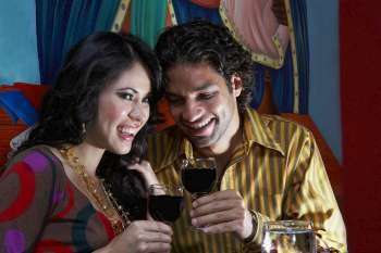 Close-up of a young couple holding glasses of red wine