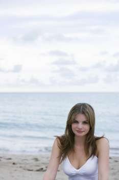 Portrait of a young woman smirking on the beach