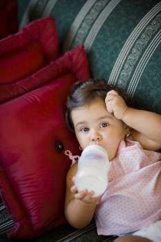 Portrait of a baby girl drinking milk with a baby bottle