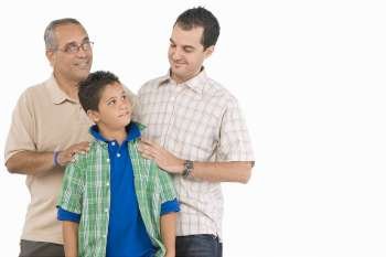 Close-up of a boy standing with his father and grandfather