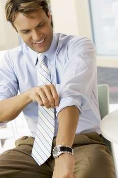 Businessman adjusting his sleeves and smiling
