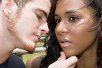 Close-up of a young man about to kiss a teenage girl