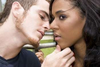 Close-up of a young man kissing a teenage girl