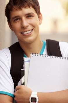 young man with notebooks, selective focus on eye, natural light
