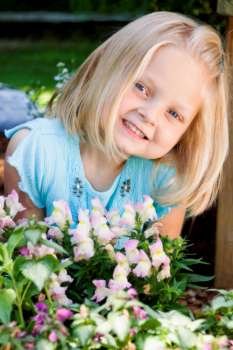 Girl smiling by flowers, portrait
