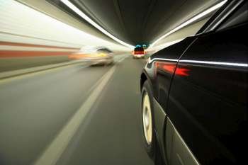 Blurred motion image of cars driving through tunnel