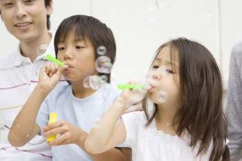 Asian children blowing bubbles