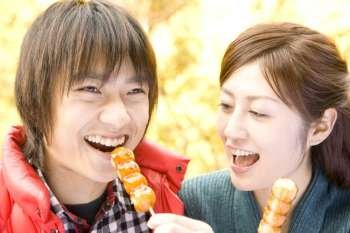 Smiling teenage couple eating