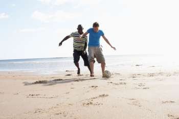 Two Young Men Palying Football On Beach Together