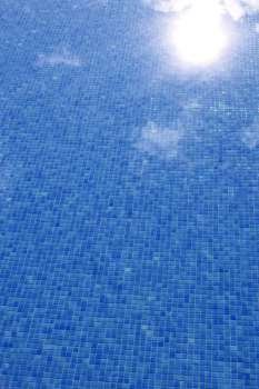 blue tiled swimming pool with sun reflexion summer vacation background  
