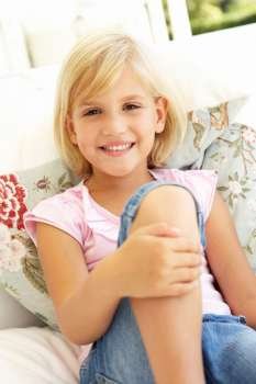 Portrait Of Young Girl Relaxing On Sofa