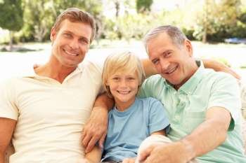 Portrait Of Grandfather, Son And Grandson Relaxing On Sofa