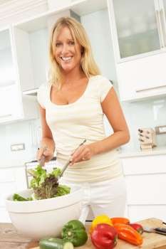 Woman Preparing Salad In Modern Kitchen