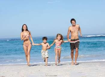 Young Family Running Along Beach on Holiday