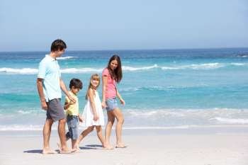 Family Walking Along Sandy Beach