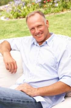 Middle Aged Man Relaxing In Garden