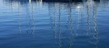 Boats abstract reflexion over blue mediterranean saltwater