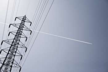 Aeroplane gliding over an electricity pylon