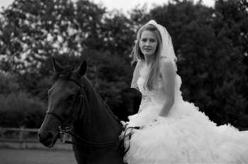 Woman in a wedding dress on a horse.