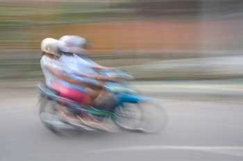 Blurred image of people riding a motorbike in Bali