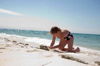 Young girl playing in the sand on Belizean Isle in Belize