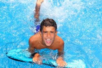 boy teenager surfboard splashing blue water happy in sea pool