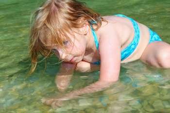 blond girl swimming in lake river beautiful blue eyes child