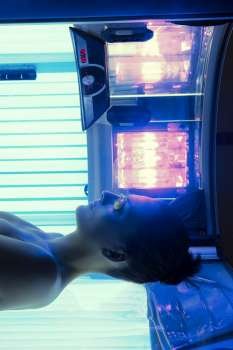 Tanning solarium young woman lying real light on