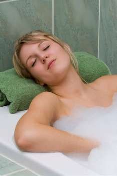 A young woman relaxing in a bath full of bubbles