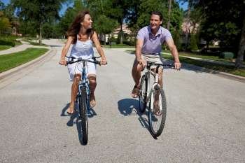 Two attractive adults, man and woman couple, cycling together.