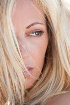 Close up portrait of a beautiful blond woman, shot outside in natural light with the focus on her eye.