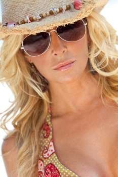 Stunningly beautiful and sexy young blond woman in straw cowboy hat and sunglasses
