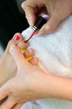 Close up of a beautician painting a client´s toe nails during a pedicure