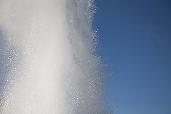 Spray of geyser steam in the blue sky