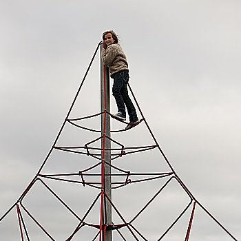 Girl climbing atop triangular rope structure