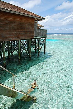 young adult relaxing on translucid water in a Maldivian Island