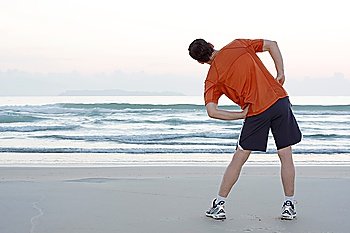 Jogger doing stretching on a beach