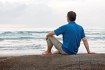 Man sitting on a rock at the sea
