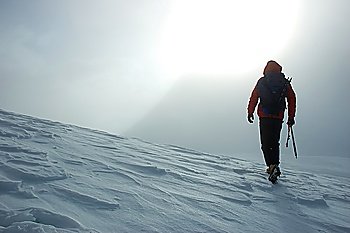 A lonely climber reaching the summit of the mountain