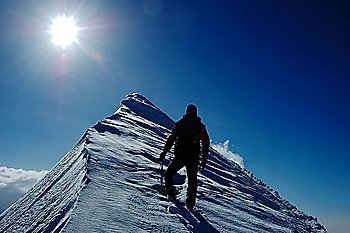A lonely climber reaching the summit of the mountain