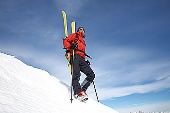 Male backcountry skier against blue sky; italian alps