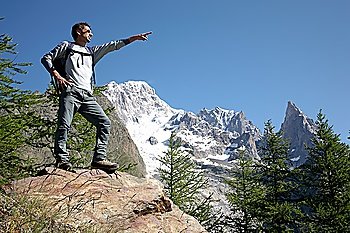 Young male hiker pointing to somewhere; mountain scenic, Mont Blanc, Italy.