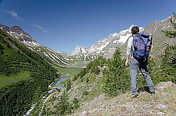 Male hiker enjoying the view over the beautiful landscape of Mige Lake, Mont Blanc, Courmayeur, Italy
