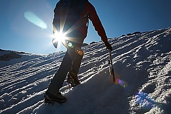 Lone male mountain climber climbing a snowy ridge; Mont Blanc, Europe.