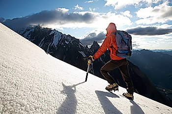Lone male mountain climber climbing a snowy ridge; Mont Blanc, Europe.
