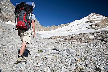 Hiker walks on a mountain path, Gran Paradiso Park, Italy