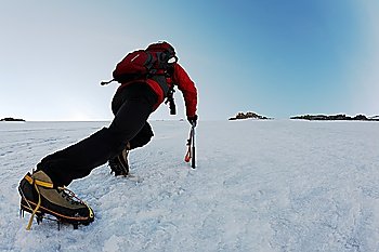 Mountaineer climbing a steep route on a icy slope, italian Alps, Europe.